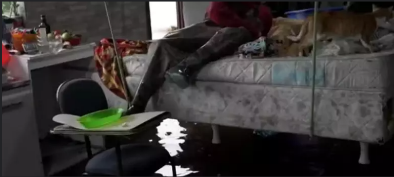 Homem pendura cama no teto durante enchente no RS