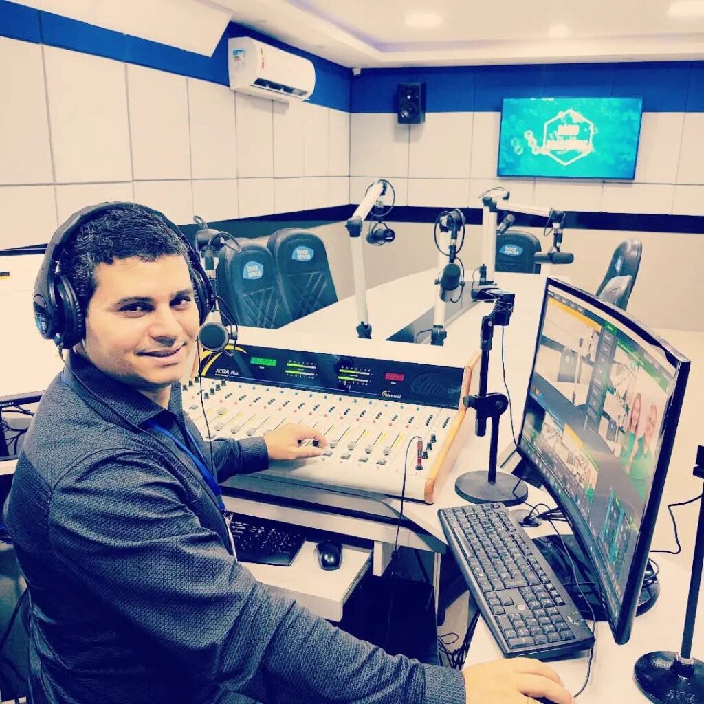Radialista Johnnys Moura operando mesa de transmissão.