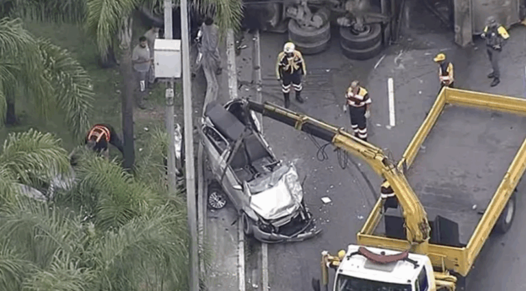Motorista fica preso às ferragens após caminhão de lixo tombar na Marginal Tietê