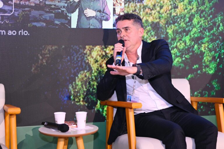 Prefeito David Almeida discursando no palco, durante COP30.